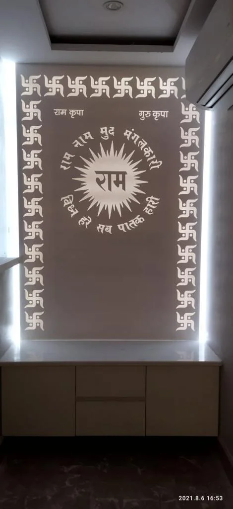 Modern Hindu prayer space with custom wall panel, Sanskrit text, Swastika symbols, and illuminated panels.