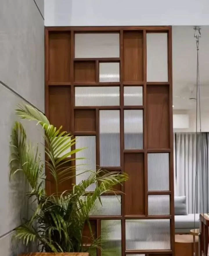 Modern wood and glass room divider with green plant.